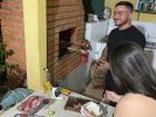 Mis vecinos conversan mientras cocinan la carne a la parrilla