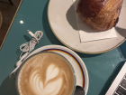 A caffe latte with a chocolate croissant 