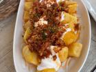 Patatas Bravos (Bravo potatoes) with crispy onions with garlic aioli sauce- a beloved Spanish tapas classic 