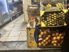 The local fruit stand has a pet cat, he likes to guard the oranges