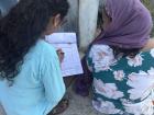 Local nurse performing eye screening questionnaire with a new mother