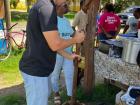 Parker helping mash the mixed plantains using a large mortar and pestle