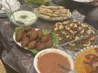 This is a gorgeous homemade appetizer spread featuring stuffed grape leaves, mskhan rolls and kibbeh along with dressings and a salad