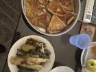 This is a lunch composed of pastries and a plate of stuffed zucchini, cabbage and grape leaves