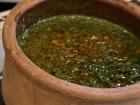 A close-up look of hearty molokhiyeh stew, garnished with fried garlic 