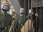 A recreation of East German police at peaceful anti-communist protests. Under their helmets are videos from the 1980s protests!