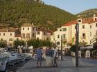 Locals chat by the port in Komiža, a fishing town