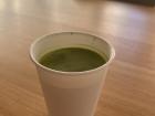 Some fresh matcha tea, served in a rustic paper cup.