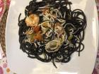 A common seafood dish: black noodles, dyed with octopus ink, eating with shrimp and fish