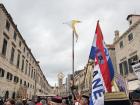 Participants in traditional dress carry banners and flags through Dubrovnik’s Old Town during a historic local procession