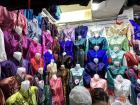 This is a deel stall at a market, displaying a wide variety of colors and styles of traditional Mongolian deels