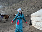 This is me wearing a traditional Mongolian deel at my coworker’s relatives’ place in the countryside: their ger on the right and farm animals to my left