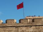 This is the Moroccan flag on a castle that overlooks the river and the ocean, called Oudaya