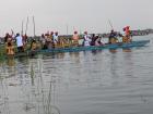 Men in traditional dress paddling a canoe