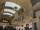 The train station in Milan has beautiful architecture and shops within the station