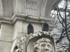Two birds perched at a fountain in the metropolitan area.