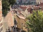 Walking down the Old Castle Stairs in Prague after grabbing a bite to eat, looking out over the city's iconic red roofs and church domes