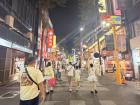 A photo of Xi Men Ding, a tourist district filled with many shops, bright signs, shining lights and loud music