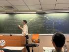 A photo of my film class professor explaining the relationships in the movie Prince of Egypt to us using a blackboard