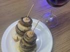 Sauteed mushrooms (champiñones) with garlic and oil, topped with a shrimp that is skewered on top of a slice of fresh bread