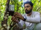 Siddhanta Pandey sets a camera trap outside of a pangolin burrow