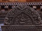 Bhaktapur's buildings are covered in intricate wood carvings, like this piece hanging above a doorway